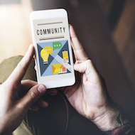A man holding a phone in his hand and has the word community on it