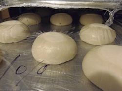 several medium dough balls sitting on a tray