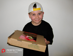 Small boy holding a pizza box smiling