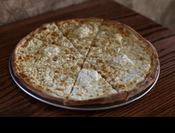 American White Pizza with Ricotta sitting on a wooden table.