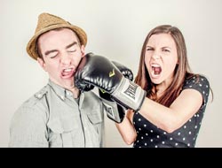 Woman with boxing gloves punching a man in the face