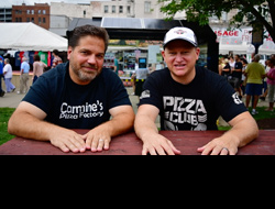 Siler Chapman and Carmine Testa sitting at a picnic table at a festival giving an interview