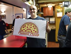 Scott Anthony holding a large pizza box smiling