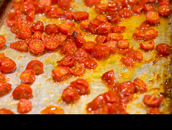 Carmelized cherry tomatoes in olive oil on a sheet pan